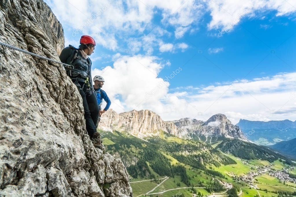 two mountain climbers on a steep climb in the Dolomites with a great view