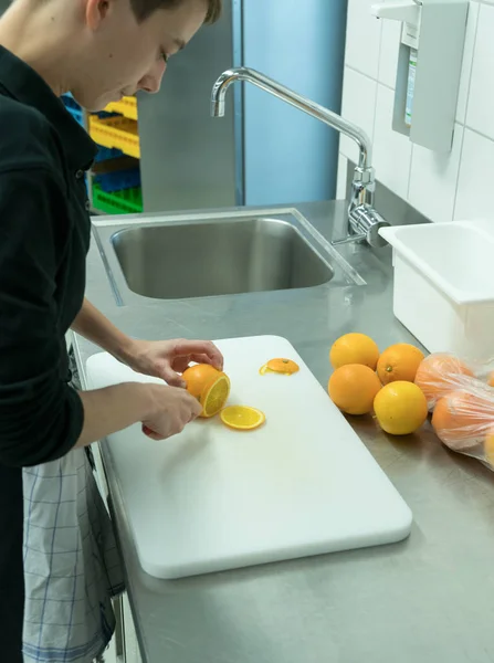 Jonge Vrouwelijke Kok Knippen Snijden Van Verse Sinaasappelen — Stockfoto