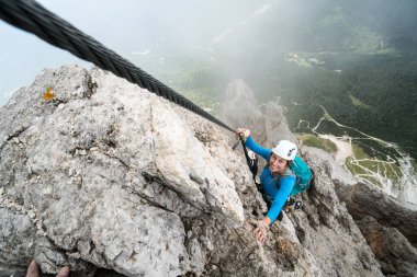 genç çekici kadın dağcı bir dik ve savunmasız Via Ferrata İtalyanca Dolomites South Tyrol Alta Badia içinde üzerinde