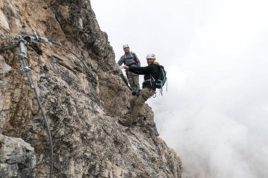 Via Ferrata tırmanma dik ve maruz rock yüzünde Genç dağcı