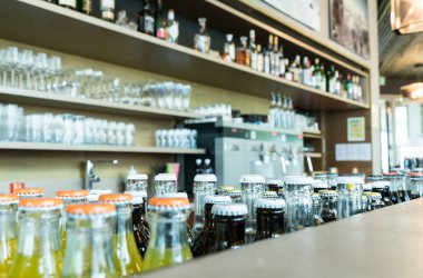 seçici odak birçok içecekler ve meyve suyu, içecekler ve şık bar ve lounge ile kahve makinesi ve şişe ve bardak arkasında