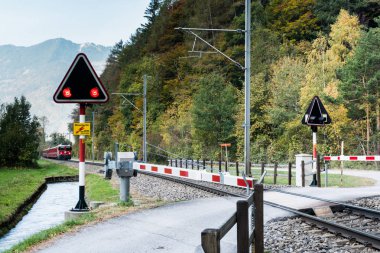 Uyarı lambaları ve İsviçre kırsal kesimde yaklaşan trenin kırmızı yanıp sönen ile railraod geçiş