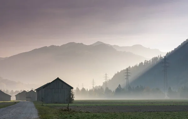 Ochtendnevel Een Bergdal Met Velden Oude Houten Schuren Lattice Grensoverschrijdende — Stockfoto