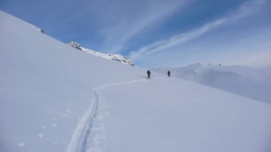 iki backcountry kayakçılar bir tırmanmaya uzak dağ tepe doğru yola yeni parça koyarak Avusturya Alpleri'nde