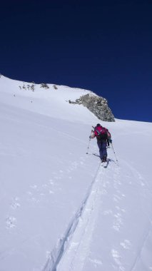 birkaç backcountry kayakçı zammı ve bir güzel kış gününde bir uzak dağ tepe İsviçre tırmanmaya