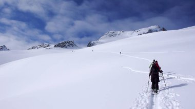 bir grup backcountry kayakçı zammı ve uzak dağ tepe İsviçre tırmanmaya