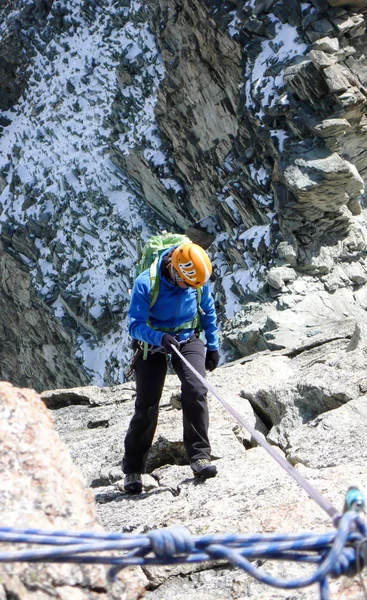 在瑞士阿尔卑斯山采尔马特上空 女性登山者从高山山峰上跳下 — 图库照片