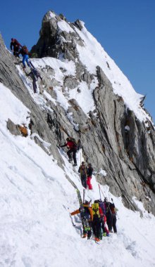 birkaç backcountry kayakçı zammı ve tırmanmaya uzak dağ tepe İsviçre bir güzel kış gününde
