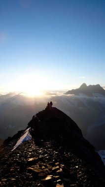 dağcılar gündoğumu tırmanma Eiger Dağı İsviçre Alpleri'nde, kayalık bir sırt üzerinde