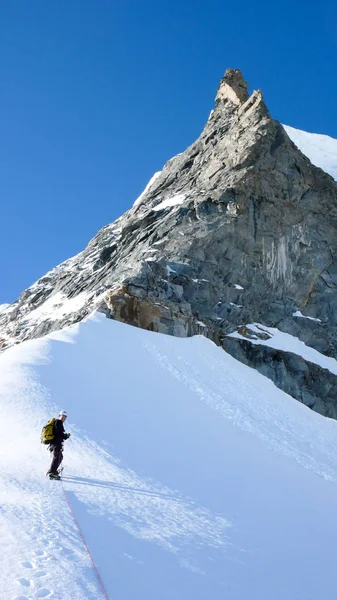 Bergklättrare Stående Snö Och Nedanför Skarp Sten Nål Bergstopp Blå — Stockfoto