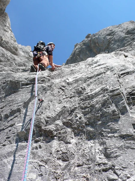 男性登山クロスタース近くスイス アルプスのルートを登る急な岩の上 — ストック写真