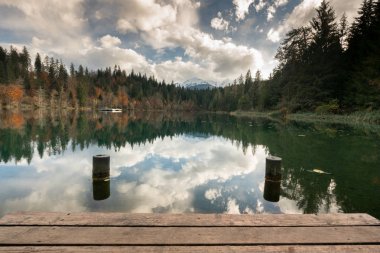 ahşap iskele ve tahta ile sonbahar renk ormanıyla çevrili bir cennet gibi dağ Gölü kenarında dock dikmesi