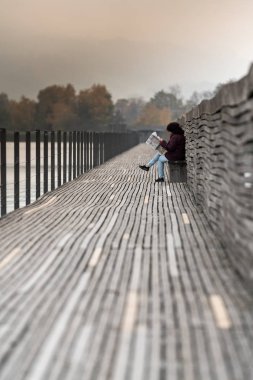 Rapperswil, Sg / İsviçre - 5 Kasım 2018: orta yaşlı kadın Hurden için önde gelen ünlü tahta bankta üzerinde 