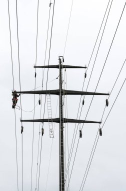 yüksek gerilim enerji hatları üzerinde kafes yüksekte çalışma profesyonel adam haçlar tehlikeli elektrik işi