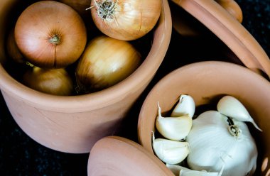 soğan ve sarımsak ile kil kavanoz görünümü üzerinde bir siyah granit masa üstü yemek pişirmek için hazır kadar kapatın