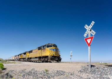 Alamogordo, Nm / Amerika Birleşik Devletleri - 10 Temmuz 2016: Union Pacific yük treni tarihinde karayolu 54 Alamogordo dışında bir demiryolu geçiş New Mexico çölünde haçlar