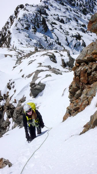 female mountain climber on a steep route to a high mountain peak in the Swiss Alps above Grindelwald