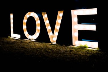 Parlak harflerle yazılmış aşk sözcüğüyle karanlık bir gece.
