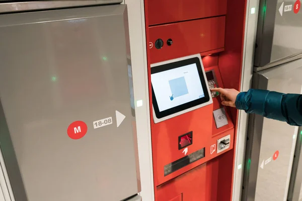 female tourist uses the luggage storage facility at the train station in Zurich in Switzerland to leave her bags in a locker