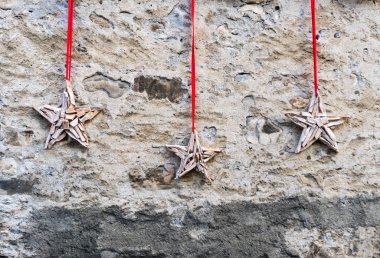 üç yıldız şeklinde dekoratif aksesuarlar dışarı deon kalın kırmızı iplik bir rustik taş duvar ev cephesinde asılı ahşap el yapımı