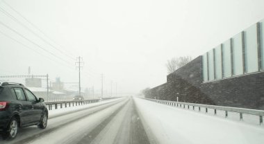 tehlikeli kış yol koşulları ile İsviçre yaklaşmakta olan trafiği yoğun kar yağışı sırasında bir karayolu üzerinde