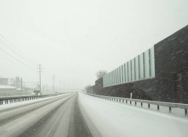tehlikeli kış yol koşulları ile İsviçre yaklaşmakta olan trafiği yoğun kar yağışı sırasında bir karayolu üzerinde