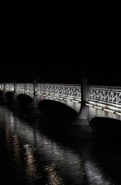 Şehir merkezi Zürih düşük anahtar etkisi gece sakin bir nehir üzerinde eski taş köprü
