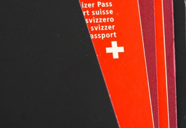 bir yığın pasaport dışarı bakmak bir Swiss passport ile görünümünü kapat