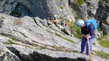 rock climbers traverse and climb the Clocher de Planpraz climbing route in the French Alps above Chamonix clipart