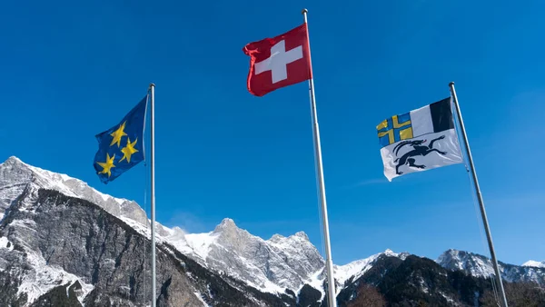 Powiewają na wietrze, w górskiej scenerii w Sw trzy flagi — Zdjęcie stockowe