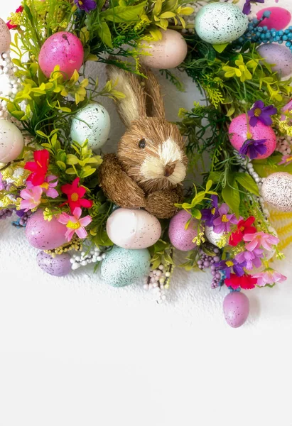 Pasen krans met kleurrijke eieren en bloemen en een konijn in de — Stockfoto