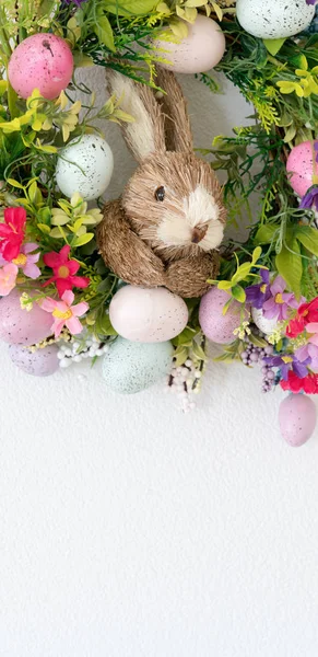 Pasen krans met kleurrijke eieren en bloemen en een konijn in de — Stockfoto