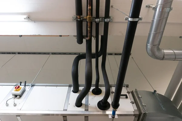 Metaal en plastic pijp systeem op het plafond van de kelder van een Appartem — Stockfoto
