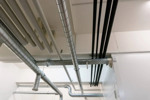 Metaal en plastic pijp systeem op het plafond van de kelder van een Appartem — Stockfoto