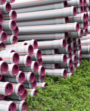 bir su inşa etmek için hazır birçok yığılmış uzun plastik boru tüpleri 