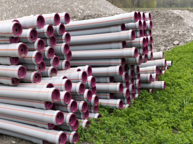 bir su inşa etmek için hazır birçok yığılmış uzun plastik boru tüpleri 