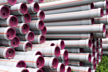 bir su inşa etmek için hazır birçok yığılmış uzun plastik boru tüpleri 