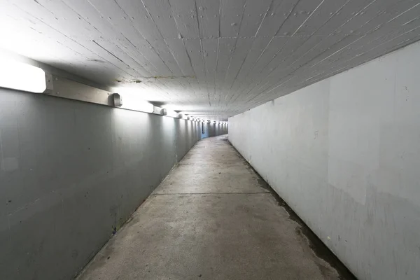 Safe and well lit underpass and concrete hallway underneath a tr — Stock Photo, Image