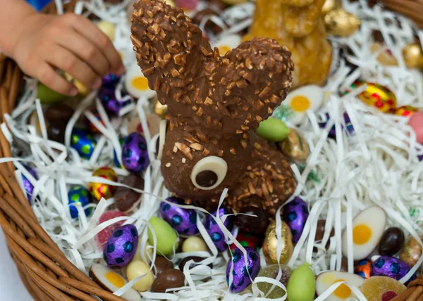 Veel kinderen handen bereiken voor snoep snoep en chocolade in een Easter Egg basket — Stockfoto