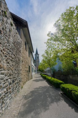 view of the old city wall and church in the Swiss village of Ste clipart