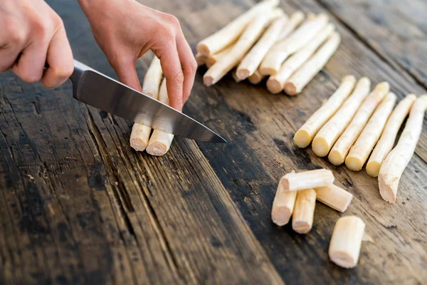 Vrouwelijke kok snijden en bereiden van witte asperges met een scherpe k — Stockfoto