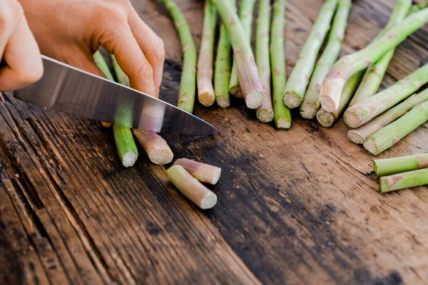 Hembra cocinar cortar y preparar espárragos verdes con una k afilada —  Fotos de Stock