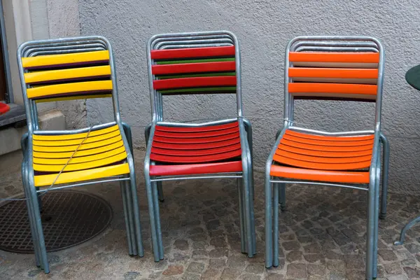 Stock image colorful garden patio chairs stacked and locked