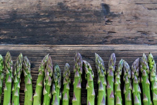 Asparagi freschi verdi biologici su un vecchio tabl di legno marrone rustico — Foto Stock