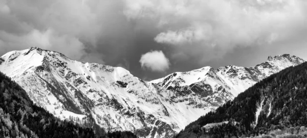 black and white panorama mountain landscape with snowcapped peaks and expressive cloudscape