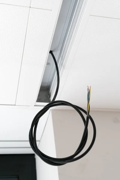 Kleurrijke elektrische kabels hangend aan het plafond in spiralen — Stockfoto