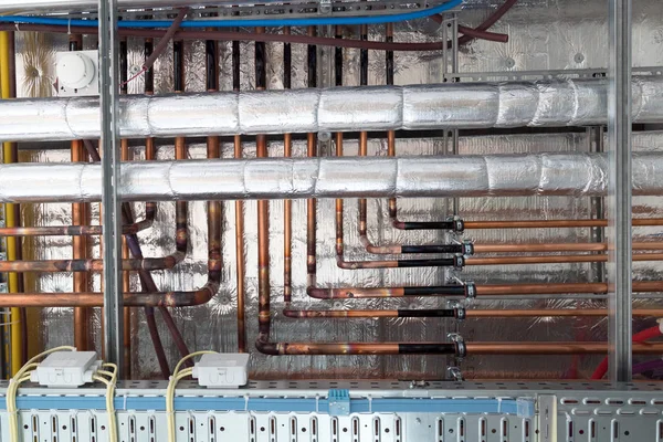 Isole les tuyaux d'eau chaude et les tuyaux en cuivre suspendus au sous-plafond — Photo