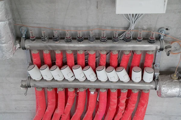 Tubos de aquecimento de piso vermelho e válvulas na rede de regulação — Fotografia de Stock