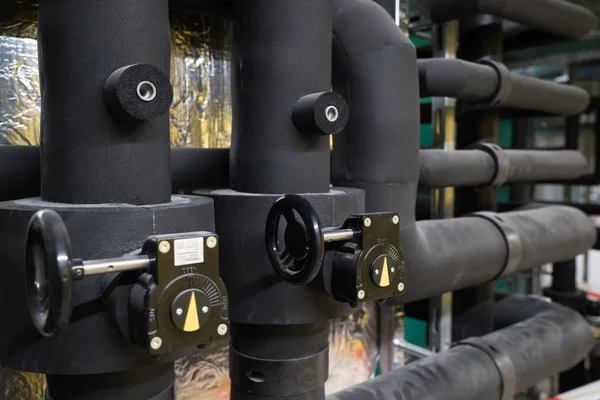 Nieuwe zwarte water ventielen met wijzerplaten en geïsoleerde zwarte pijp — Stockfoto