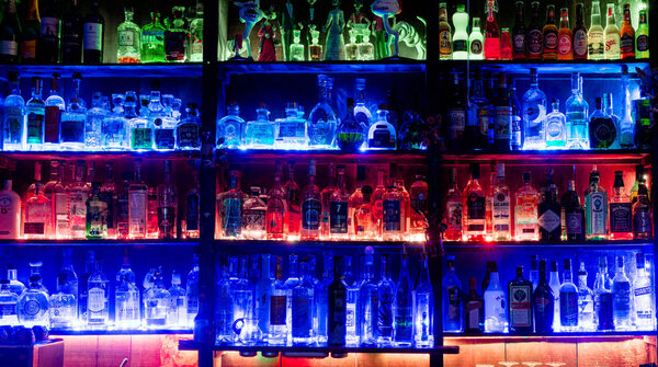 Чур, ГР / Швейцария - 14 мая 2019 года: вид на знаменитый и культовый бар Cuadro 22 в Чуре с разноцветными полками с подсветкой и большим количеством бутылок со спиртным
